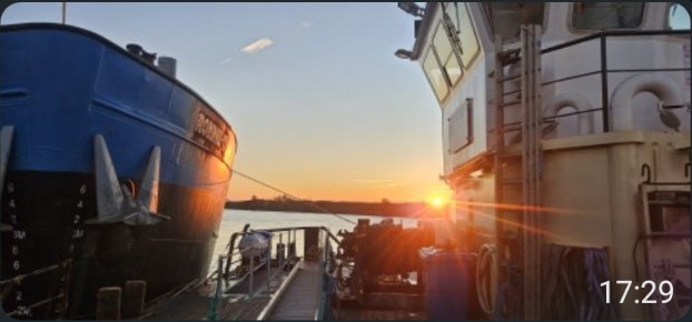 Workboats moored at the quayside at sunset